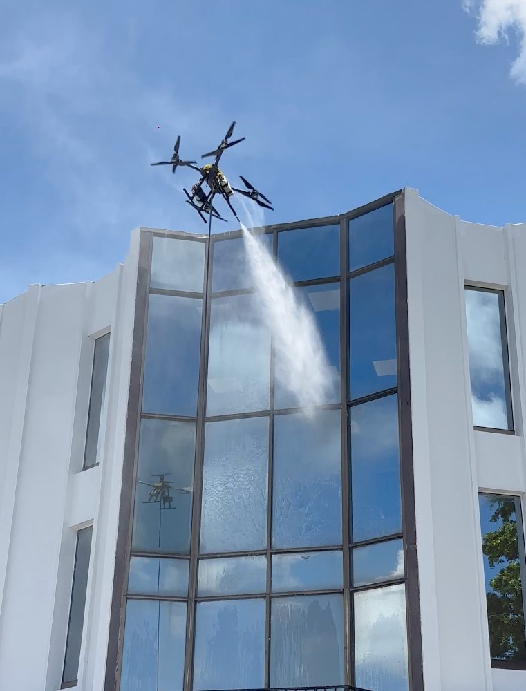 Dron de EURODRON limpiando el vidrio de una fachada acristalada de varias alturas
